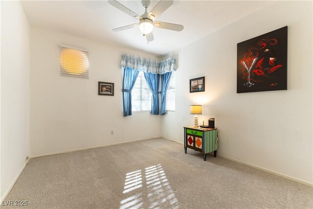 interior space featuring carpet, baseboards, and ceiling fan