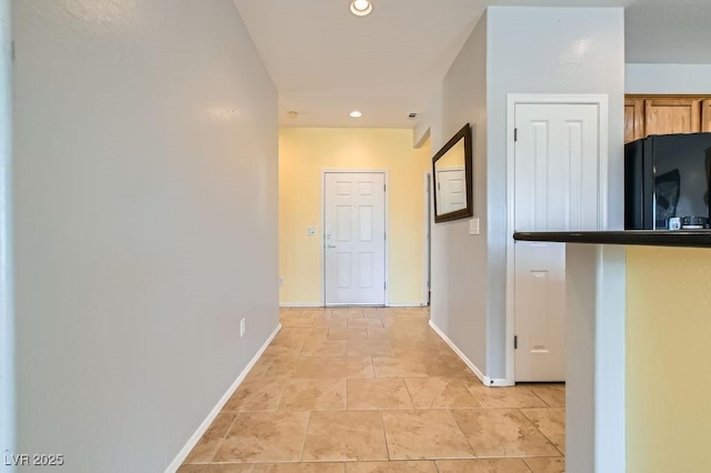 hall with light tile patterned floors, recessed lighting, and baseboards