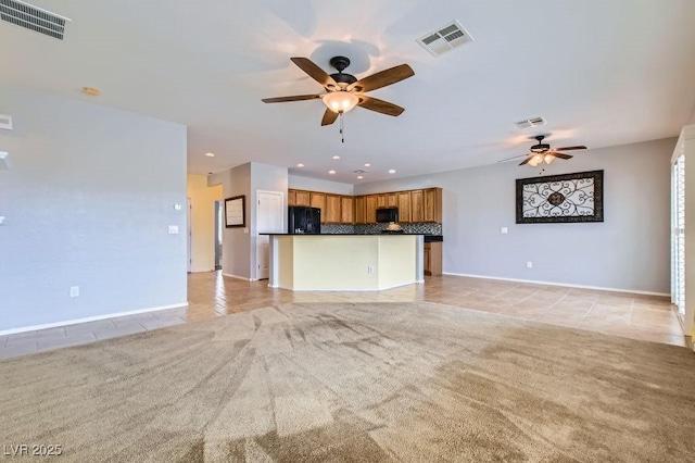 unfurnished living room featuring light tile patterned floors, a ceiling fan, visible vents, and light carpet