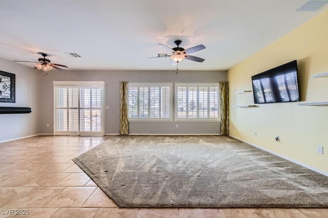 tiled spare room with visible vents, baseboards, and a ceiling fan