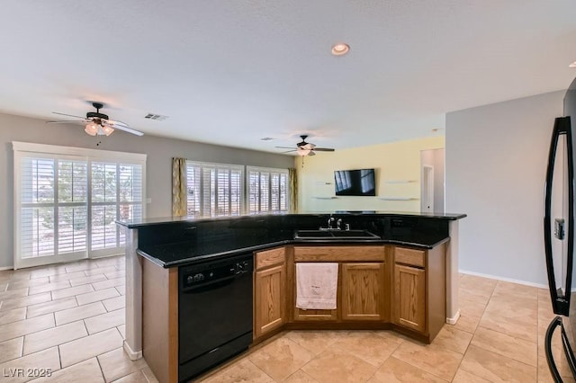 kitchen with visible vents, black appliances, a sink, dark countertops, and ceiling fan