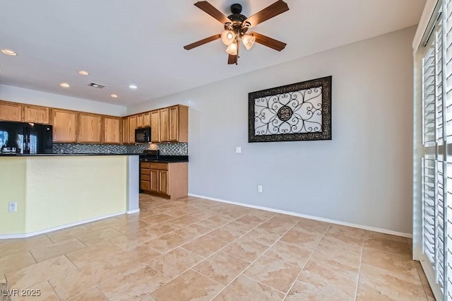 kitchen with dark countertops, visible vents, baseboards, decorative backsplash, and black appliances