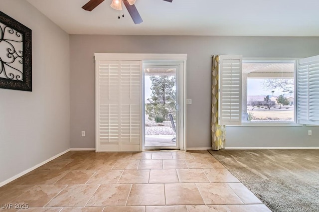 doorway to outside featuring baseboards, light carpet, and ceiling fan