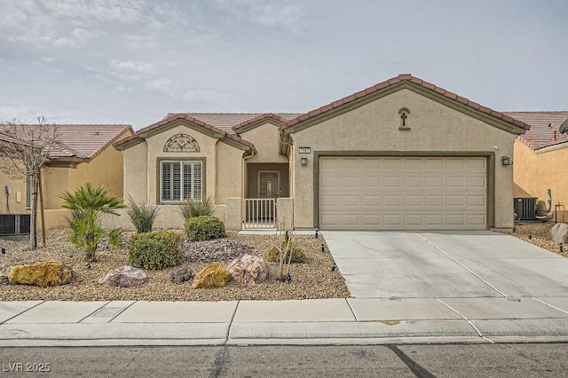 mediterranean / spanish-style home featuring a tiled roof, an attached garage, central AC unit, and stucco siding