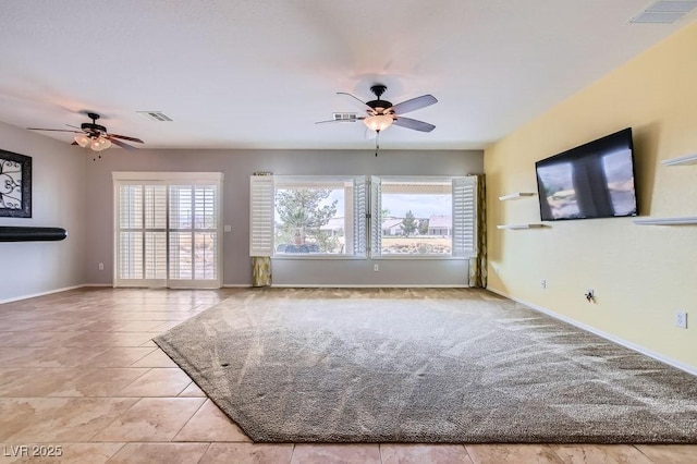 unfurnished living room with visible vents, baseboards, and a ceiling fan