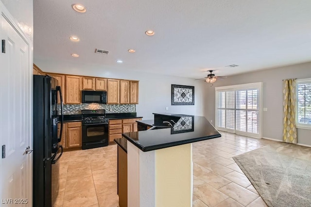 kitchen featuring dark countertops, visible vents, backsplash, light tile patterned flooring, and black appliances