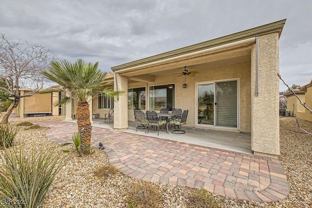 back of property with stucco siding, central AC unit, a patio area, and ceiling fan