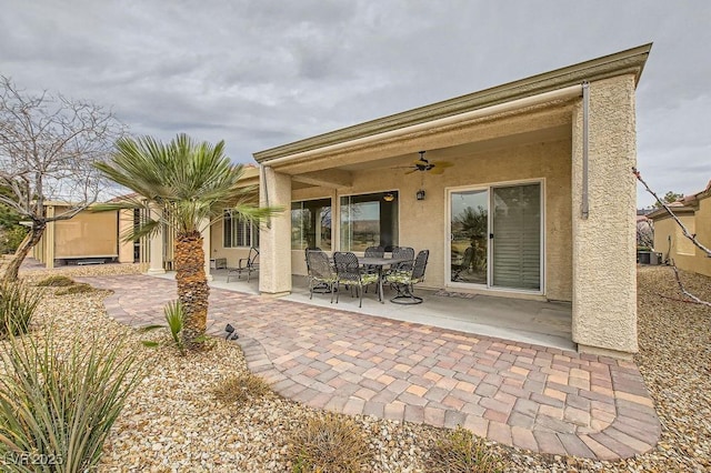 7567 Wingspread St, North Las Vegas, NV 89084 - rear view of house with ceiling fan, a patio, stucco siding, outdoor dining space, and cooling unit