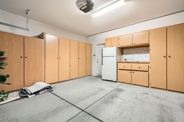 garage featuring a garage door opener and freestanding refrigerator