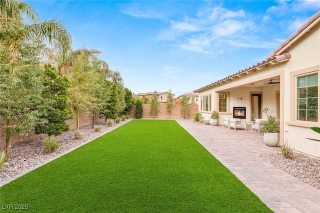 view of yard featuring ceiling fan, a patio area, and a fenced backyard