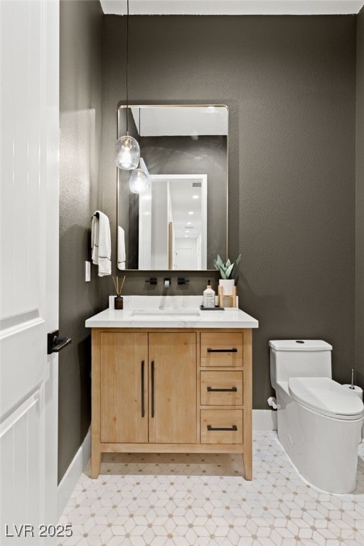 bathroom featuring toilet, tile patterned floors, baseboards, and vanity