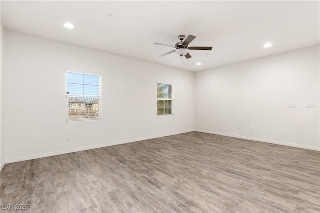 unfurnished room with plenty of natural light, ceiling fan, and wood finished floors