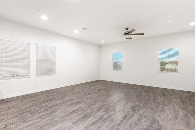 unfurnished room with visible vents, a healthy amount of sunlight, baseboards, and wood finished floors