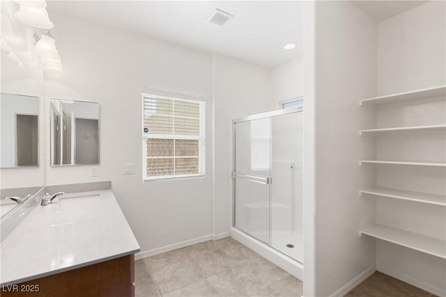 bathroom with visible vents, baseboards, vanity, and a shower stall