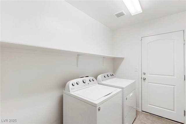 clothes washing area featuring washing machine and clothes dryer, laundry area, and visible vents