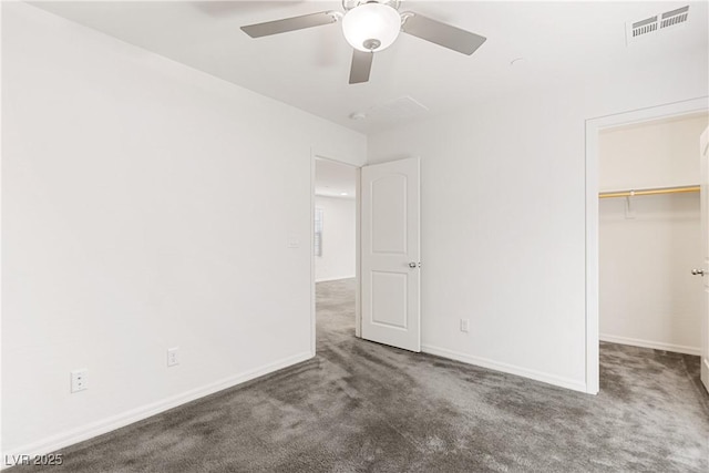 unfurnished bedroom with visible vents, a walk in closet, baseboards, and carpet floors