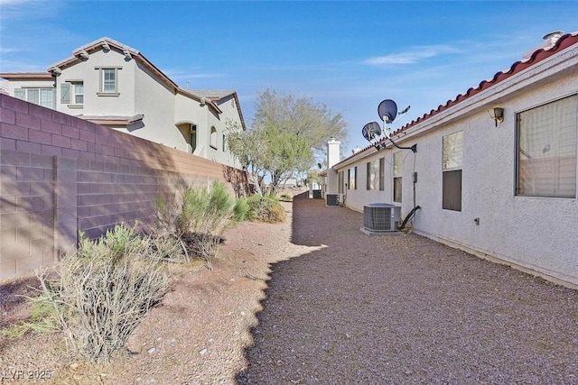 view of yard with fence and central AC unit