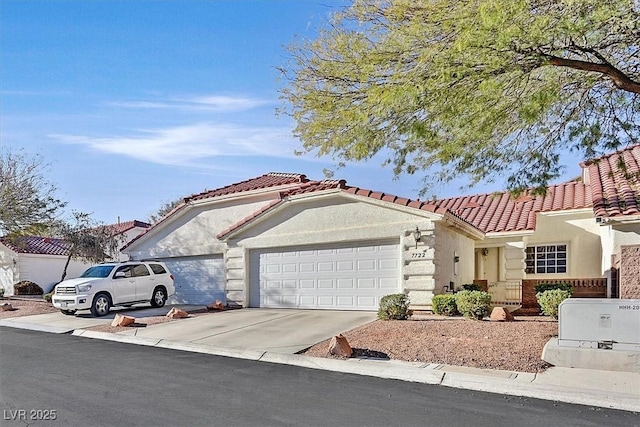 mediterranean / spanish house with a garage, stucco siding, concrete driveway, and a tiled roof