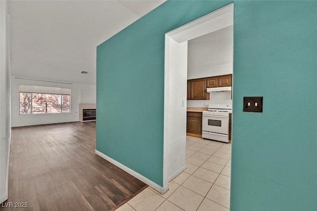 hallway featuring light tile patterned floors and baseboards