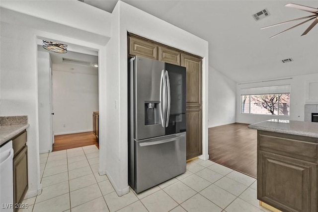 kitchen featuring light tile patterned floors, stainless steel refrigerator with ice dispenser, and visible vents