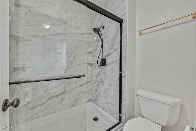 full bathroom featuring toilet and a marble finish shower