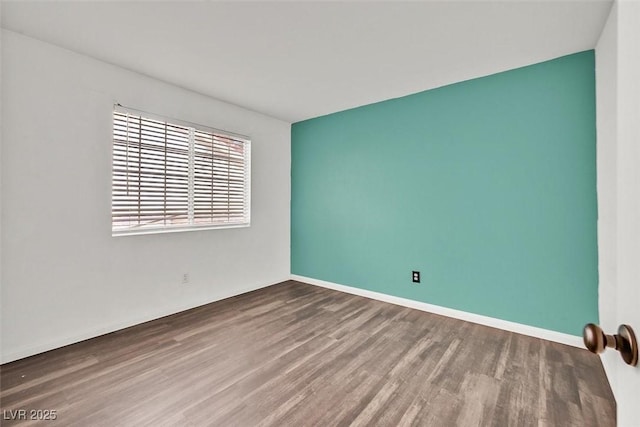 unfurnished room featuring wood finished floors and baseboards