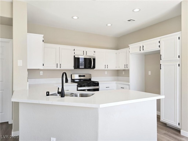 kitchen with visible vents, a sink, stainless steel appliances, a peninsula, and light countertops