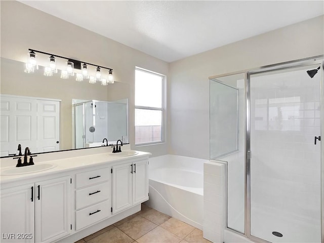 bathroom with tile patterned flooring, a garden tub, a stall shower, and a sink