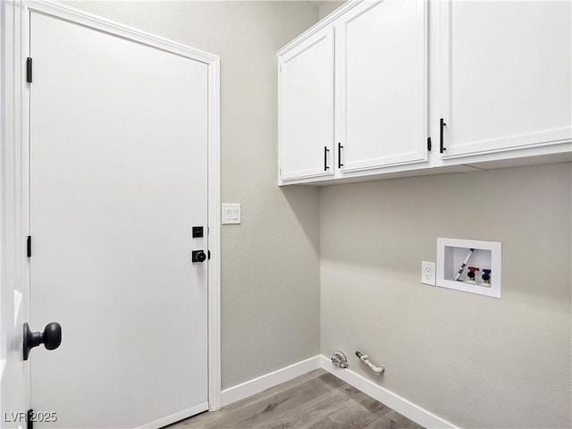 washroom with baseboards, light wood-type flooring, cabinet space, washer hookup, and hookup for a gas dryer