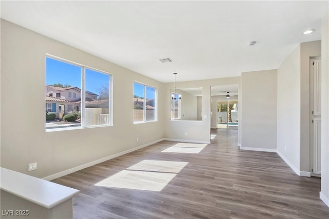 empty room with visible vents, baseboards, a chandelier, recessed lighting, and wood finished floors