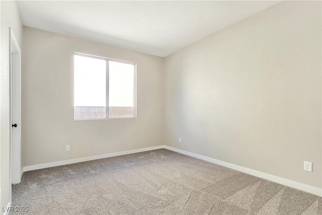 carpeted empty room featuring baseboards