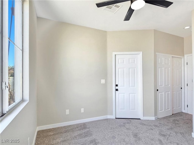 spare room with baseboards, visible vents, carpet floors, and ceiling fan