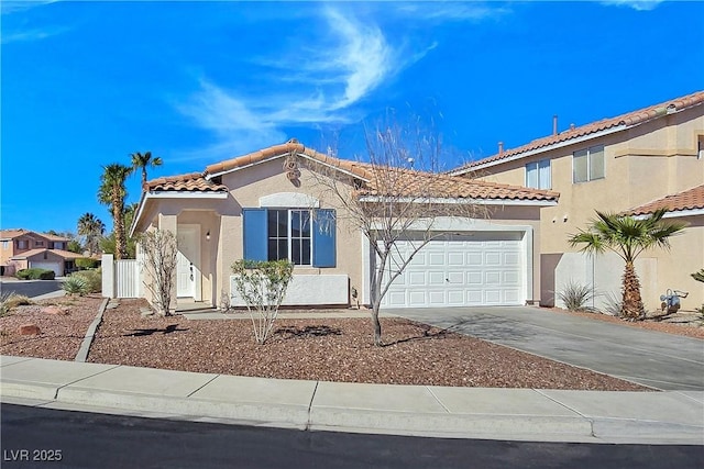 mediterranean / spanish-style home with a tile roof, stucco siding, an attached garage, and concrete driveway