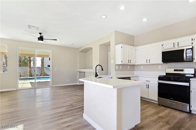 kitchen with visible vents, a sink, stainless steel appliances, a peninsula, and light countertops