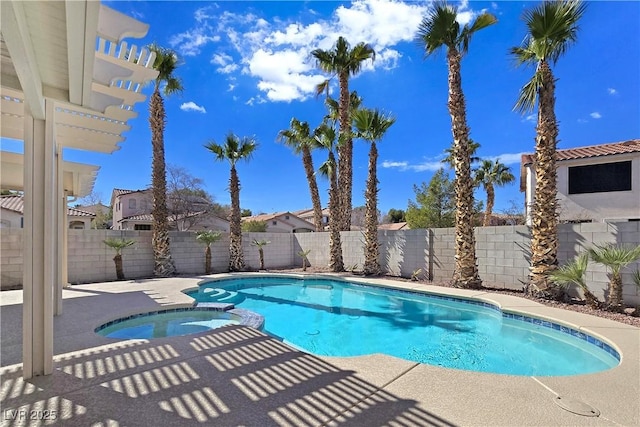 view of pool with a fenced backyard and a pool with connected hot tub