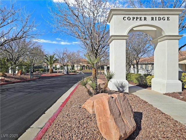 view of road with a gated entry and curbs