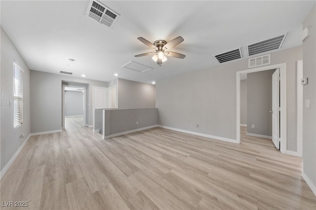 empty room featuring attic access, visible vents, and light wood-style floors