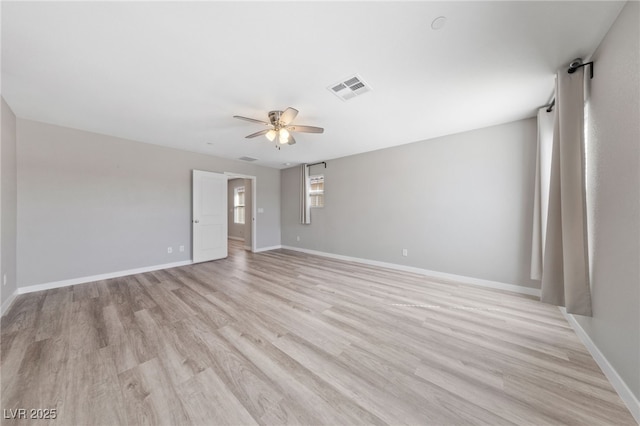 unfurnished room featuring light wood-type flooring, ceiling fan, visible vents, and baseboards