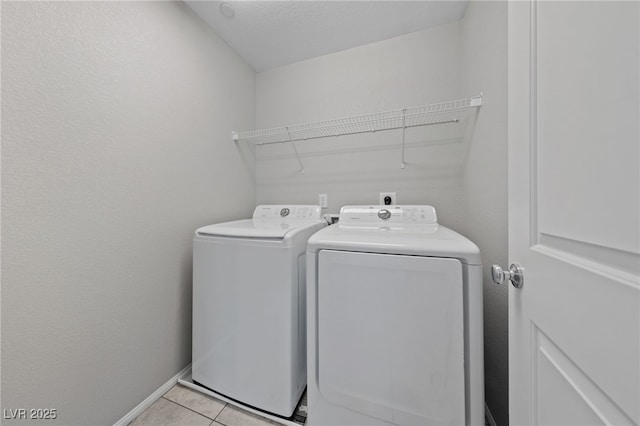 laundry room with light tile patterned floors, laundry area, separate washer and dryer, and baseboards