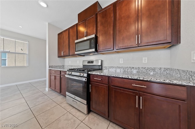 kitchen featuring light tile patterned floors, light stone counters, recessed lighting, stainless steel appliances, and baseboards