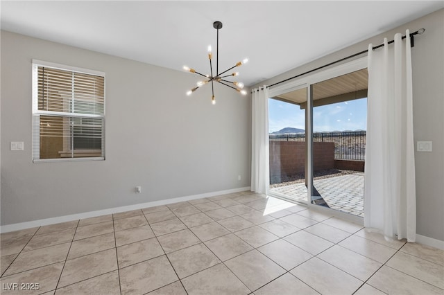 spare room featuring light tile patterned floors, baseboards, and a chandelier