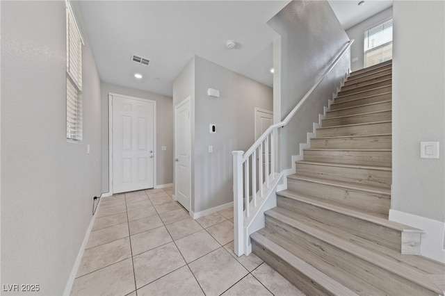 staircase featuring recessed lighting, baseboards, visible vents, and tile patterned flooring