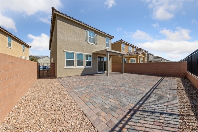 rear view of house with a fenced backyard, a patio, stucco siding, and a residential view
