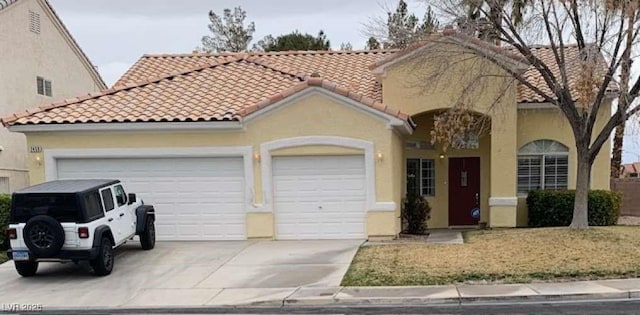 mediterranean / spanish home featuring a garage, a tiled roof, driveway, and stucco siding