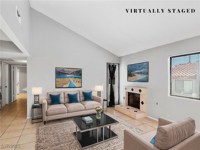 living area featuring light tile patterned floors, high vaulted ceiling, a fireplace, and baseboards