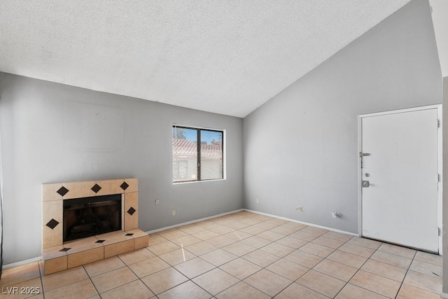 unfurnished living room featuring vaulted ceiling, a textured ceiling, a fireplace, and tile patterned flooring