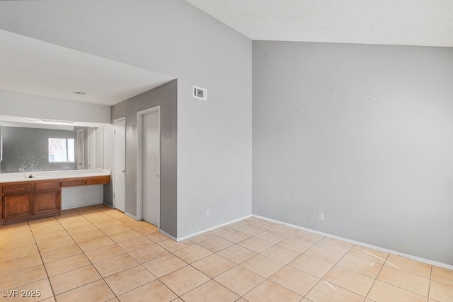 interior space featuring visible vents, built in desk, and light tile patterned flooring