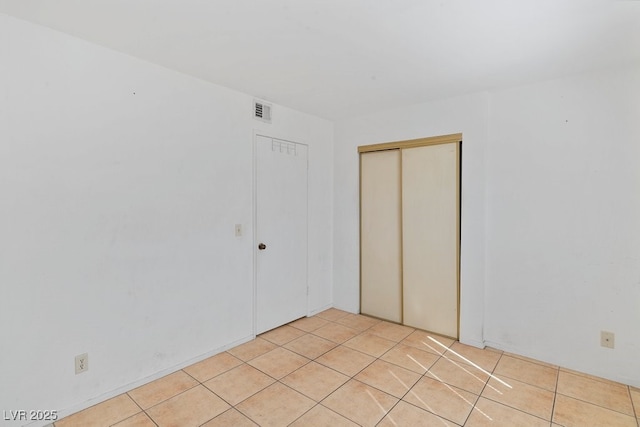 spare room featuring light tile patterned flooring and visible vents