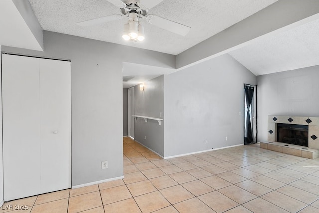 unfurnished living room with light tile patterned floors, a fireplace, vaulted ceiling, and a textured ceiling