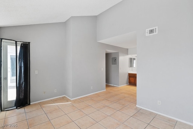 spare room with light tile patterned floors, baseboards, visible vents, and high vaulted ceiling